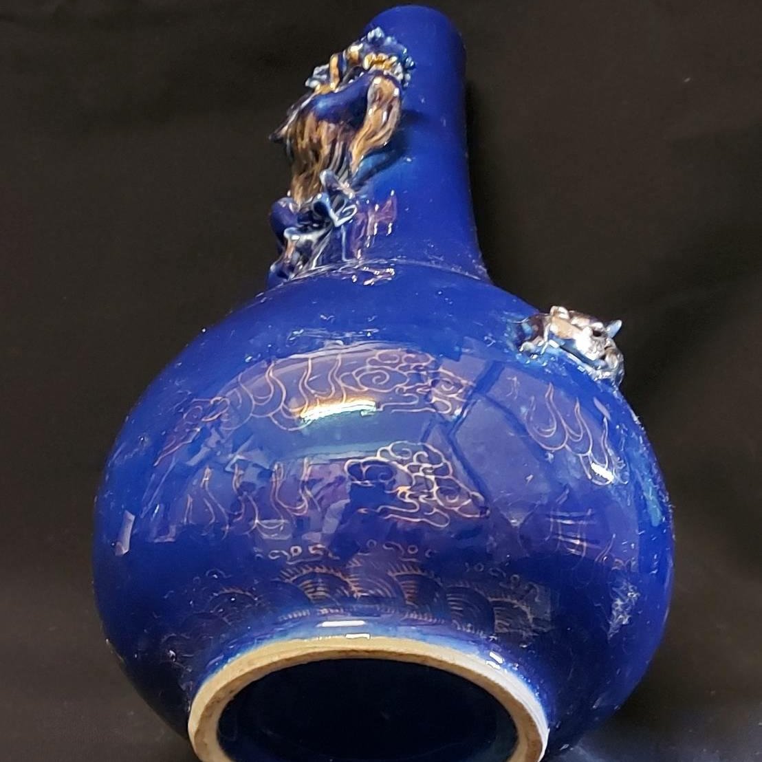 此乾隆官窯霽藍釉膽瓶，整器藍釉，以描金堆塑手法雕飾神龍盤飛祥雲之中 