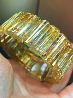 B31773高品質金黃色板狀鈦晶手排（水晶之王）金色光芒的板狀鈦絲和晶瑩透明的晶體，🔮貓眼效應光強烈能量強烈。約：21.2x9.3x6mm重量：59.4g