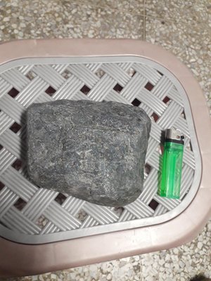 台灣墨玉，一角有環繞紋，約1.15公斤重，置於綠箱