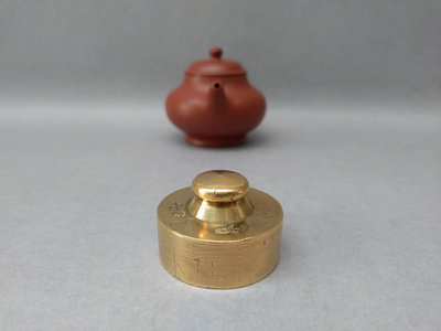 銅蓋置壺蓋托，舊砝碼，頂部、底部直徑各約1.7、4.1公分，高約2.7公分，舊砝碼做蓋置，實用又穩重。